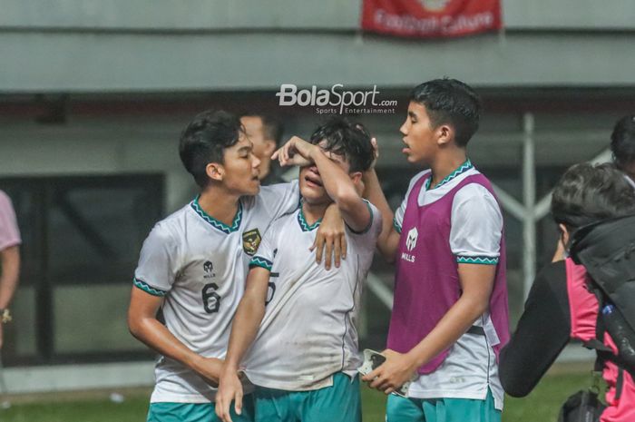 Dua pemain timnas U-19 Indonesia, Frezy Al Hudaifi (kiri) dan Razzaa Fachrezi Aziz (kanan), sedang menenangkan rekannya yang menangis bernama Zanadin Fariz (tengah) pasca gagal lolos ke semifinal Piala AFF U-19 2022.