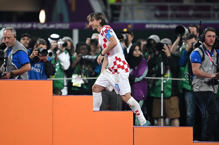 Gelandang timnas Kroasia, Luka Modric, berjalan ke podium setelah mengalahkan timnas Maroko dalam laga perebutan peringkat tiga Piala Dunia 2022 di Stadion Khalifa International, Sabtu (17/12/2022).