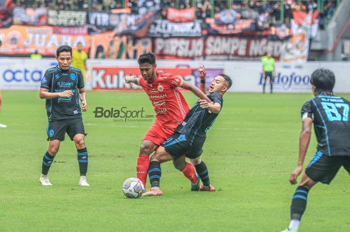 Gelandang Persija Jakarta, Resky Fandi (kiri), sedang menguasai bola dan berusaha direbut pemain Arema FC bernama Gian Zola (kanan) dalam laga pekan ke-24 Liga 1 2022 di Stadion Patriot Candrabhaga, Bekasi, Jawa Barat, 12 Februari 2023.    