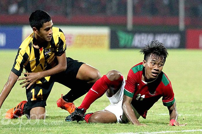        Gelandang timnas U-16 Indonesia, Mochammad Supriadi (kanan), dilanggar pemain Malaysia pada l