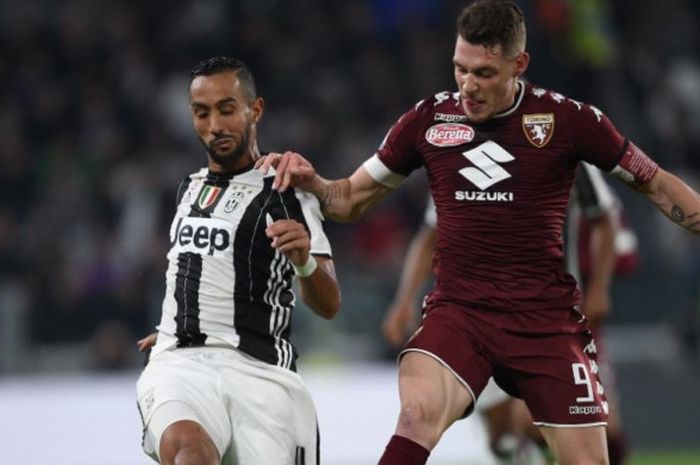 Striker Torino, Andrea Belotti (kanan), berduel dengan bek Juventus, Medhi Benatia, dalam partai Lig