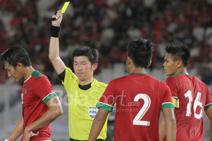 Wasit asal Jepang, Araki Yusuke, memberi kartu kuning kepada pemain timnas Indonesia, Bayu Pradana, 
