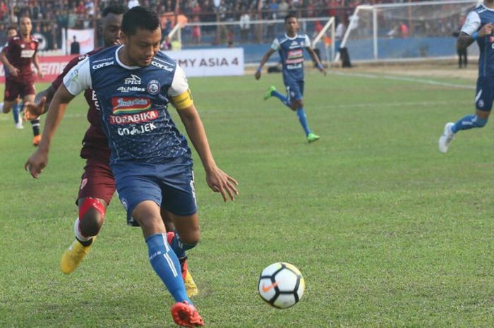 Aksi kapten Arema FC, Hamka Hamzah (depan) saat mengamankan bola dari penyerang PSM Makassar, Guy Ju