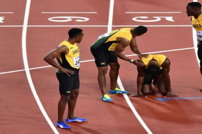 Usain Bolt (tiga dari kanan) dihibur rekan-rekannya usai gagal menyelesaikan lomba final estafet 4x1