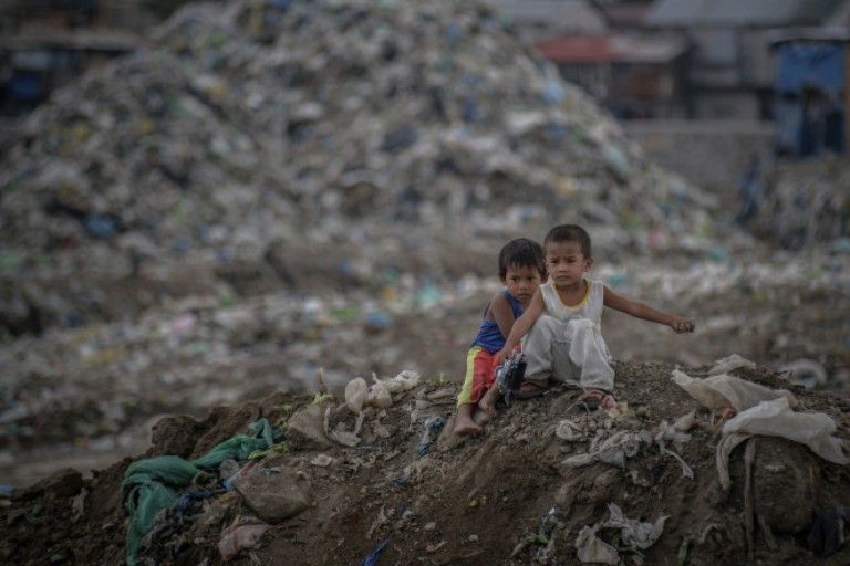 Dua orang anak di tengah-tengah tumpukan sampah di Paranaque, Filipina. 