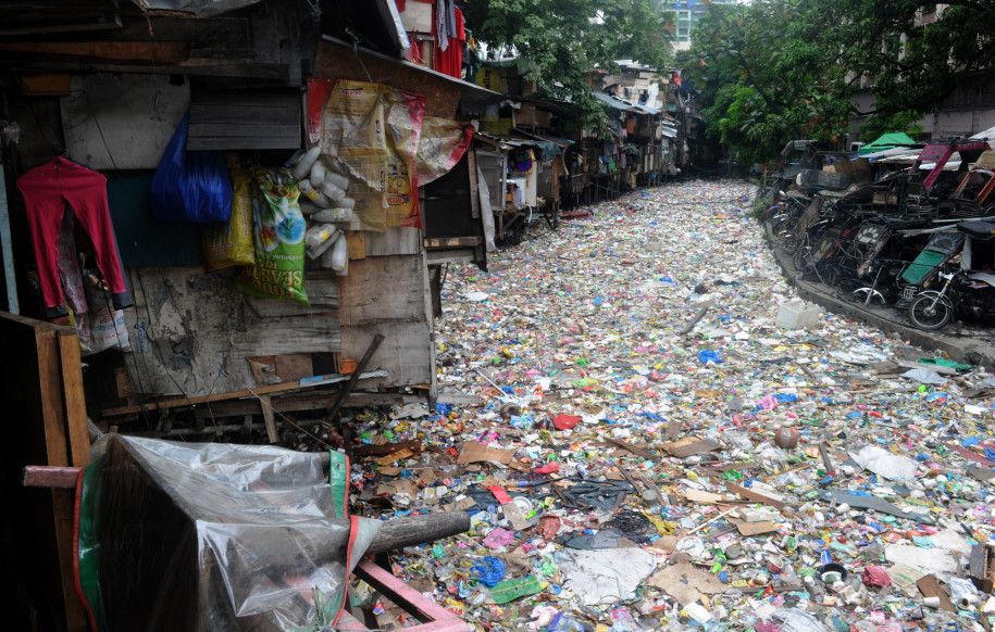 Rumah-rumah berdiri di atas sungai yang penuh sampah di Manila, Filipina.