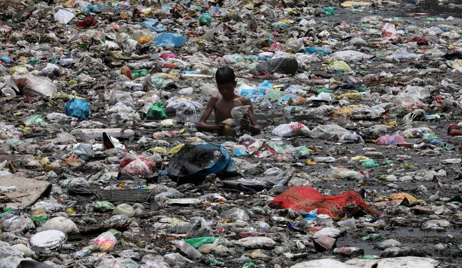 Seorang anak mengumpulkan sampah di New Delhi, India.