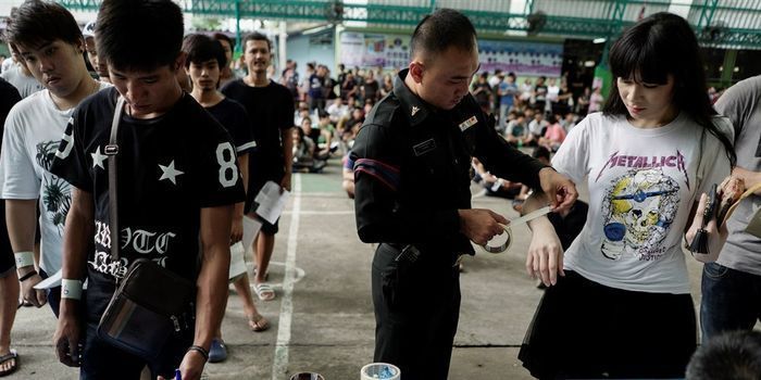 Seorang perwira militer menempatkan selotip di lengan seorang wanita transgender selama draf militer di Bangkok, Thailand, pada 5 April 2017.