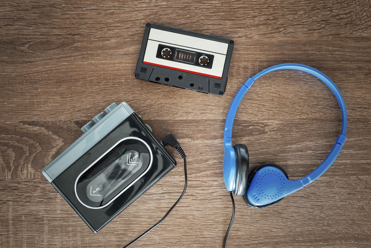 Vintage walkman, cassete and headphones on the wooden background