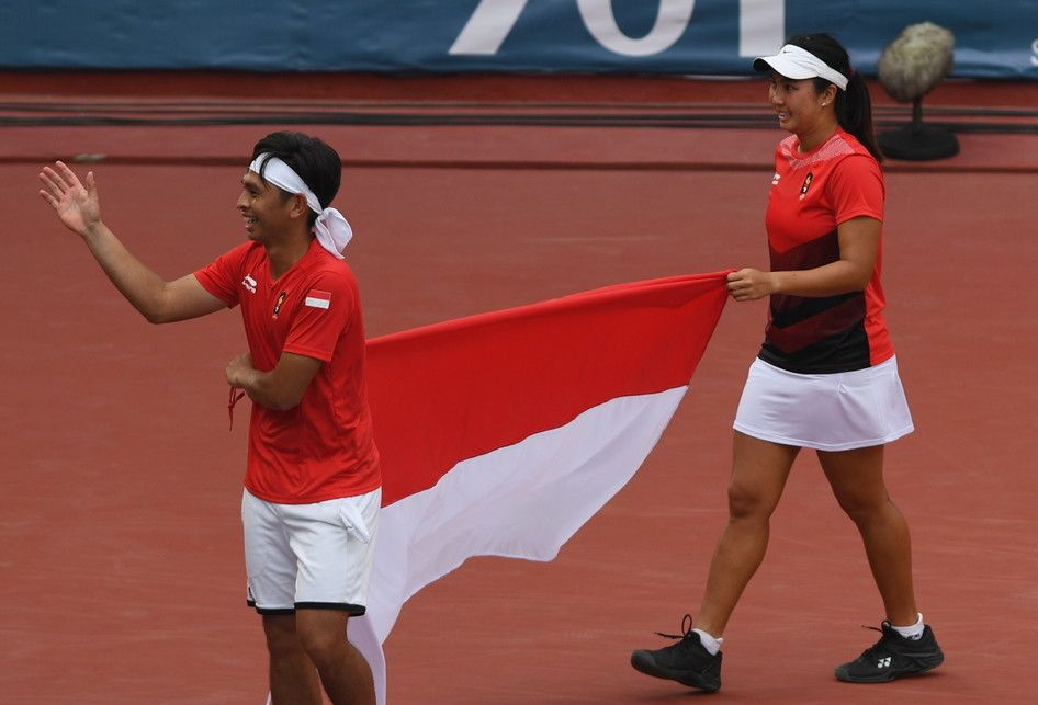 Ganda campuran Indonesia Aldila Sutjiadi (kanan) dan Christopher Rungkat membawa bendera Merah Putih