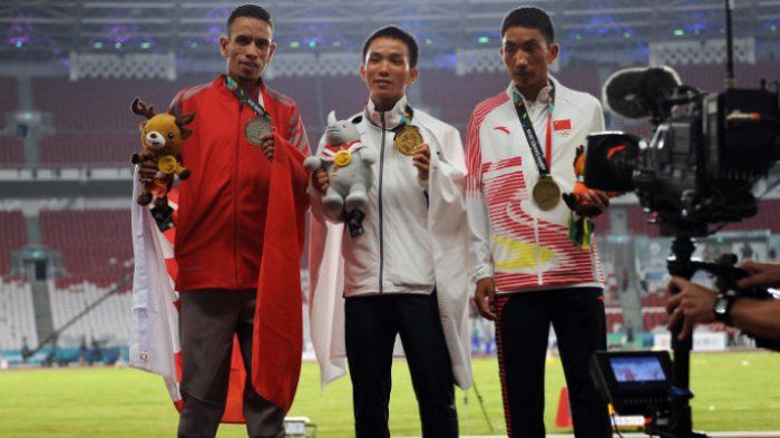 Atlet Jepang Hiroto Inoue (tengah), Elhassan Elabbassi dari Bahrain (kiri), dan Duo Bujie dari Cina memperlihatkan medalinya pada upacara penyerahan medali lari marathon putra Asian Games 2018 di Stadion Utama Gelora Bung Karno, Jakarta, Sabtu (25/8/2018). Medali emas diraih Hiroto Inoue, perak oleh Elhassan Elbbassi dan perunggu diraih Duo Bujie. 