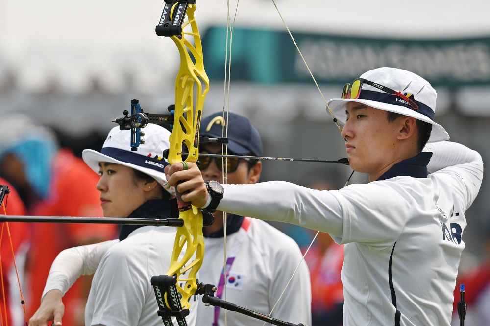 Pemanah Korea Selatan Yonghee Choi (kanan) dan Chaewon So bertanding dalam babak 12 besar nomor Comp