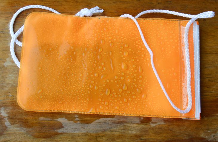 orange waterproof phone bag protection on wooden board