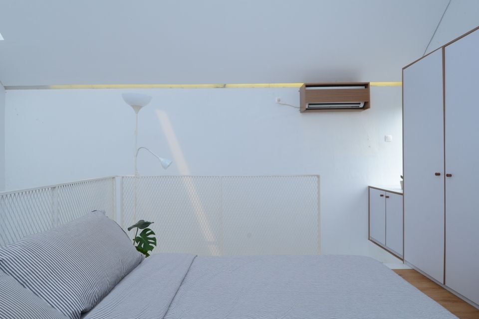 Skylight dan cat putih membuat kamar tidur tampak lebih luas dan lapang