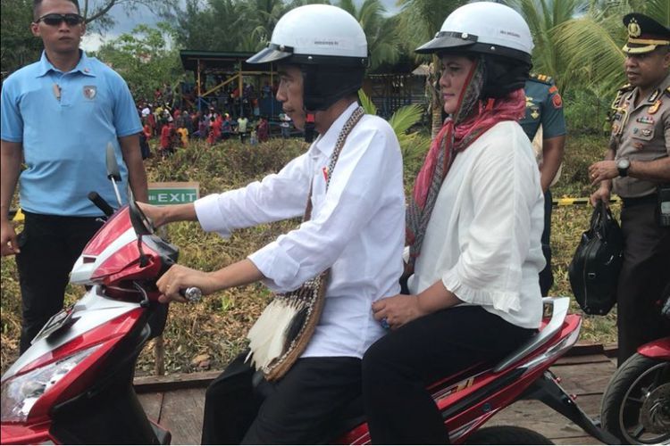 Presiden Joko Widodo memboncengi Ibu Negara Iriana saat blusukan di Kota Agats, Kabupaten Asmat, Pro