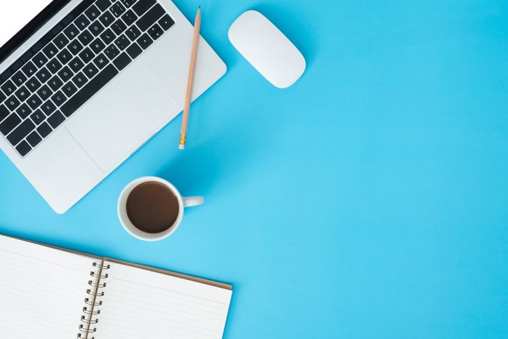 Minimal work space - Creative flat lay photo of workspace desk. Top view office desk with laptop, notebooks and coffee cup on blue color background. Top view with copy space, flat lay photography.