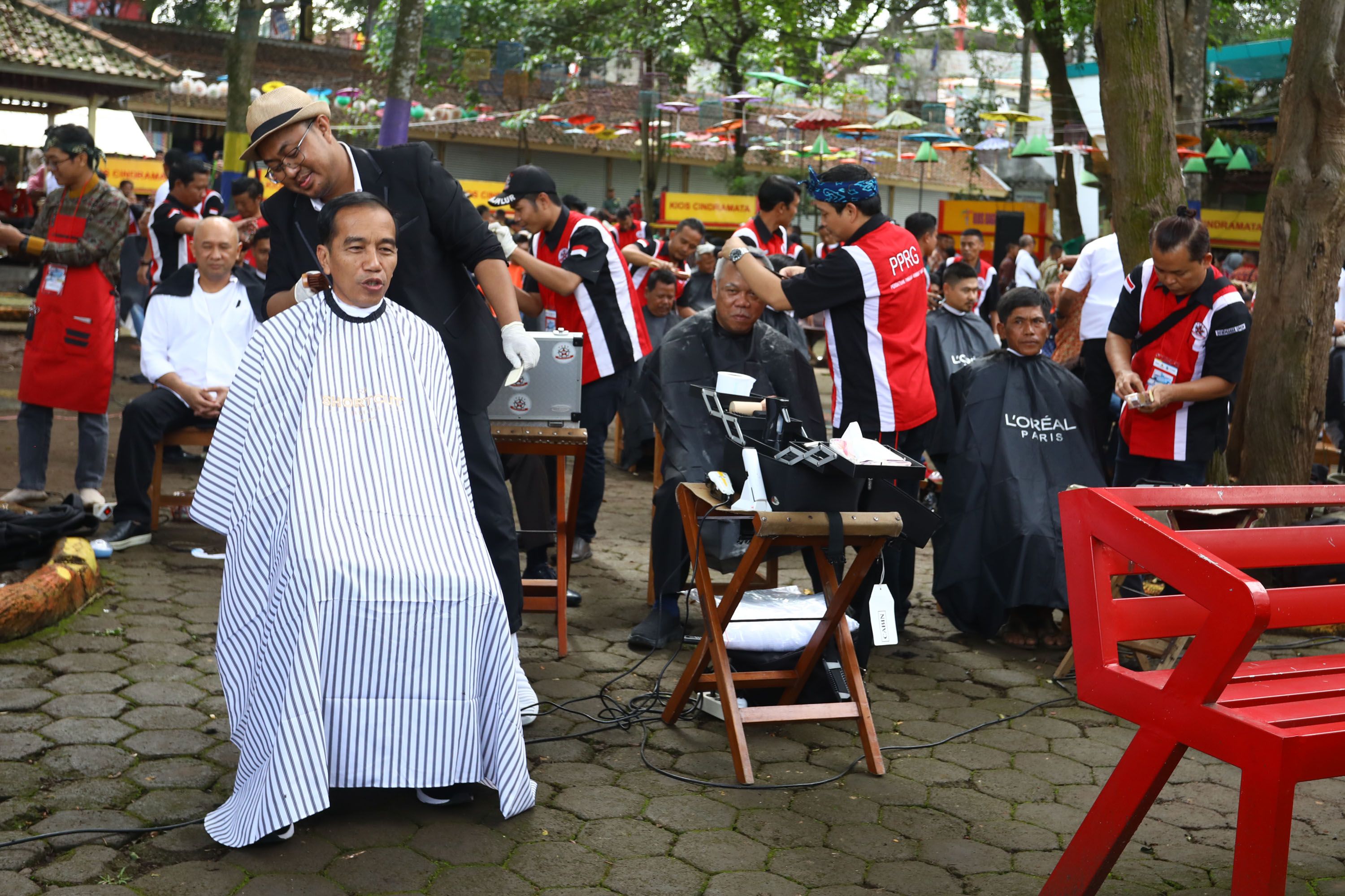 Presiden Joko Widodo mengikuti potong rambut massal di area wisata Situ Bagendit, Garut, Jawa Barat,