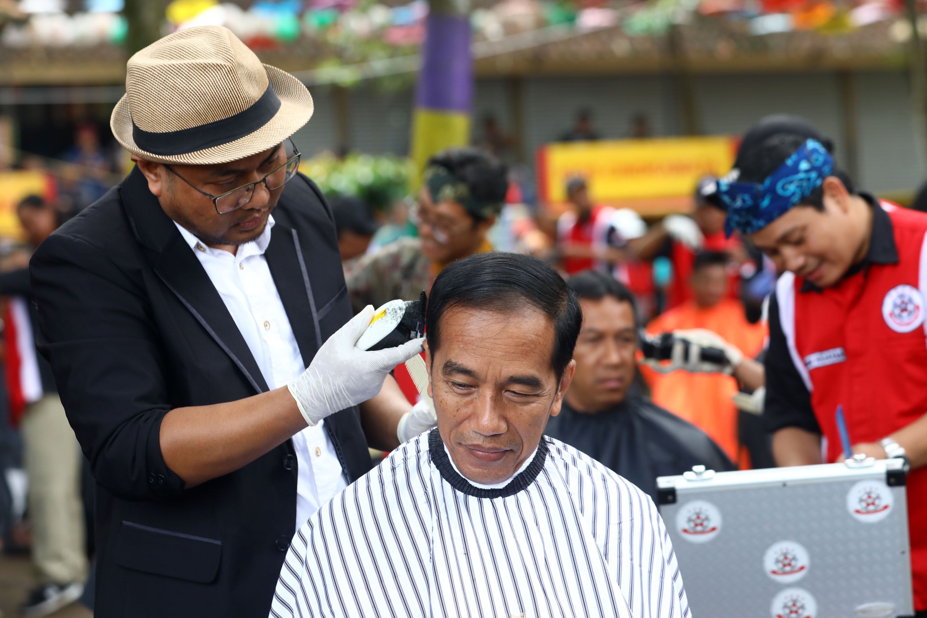 Presiden Joko Widodo mengikuti potong rambut massal di area wisata Situ Bagendit, Garut, Jawa Barat,