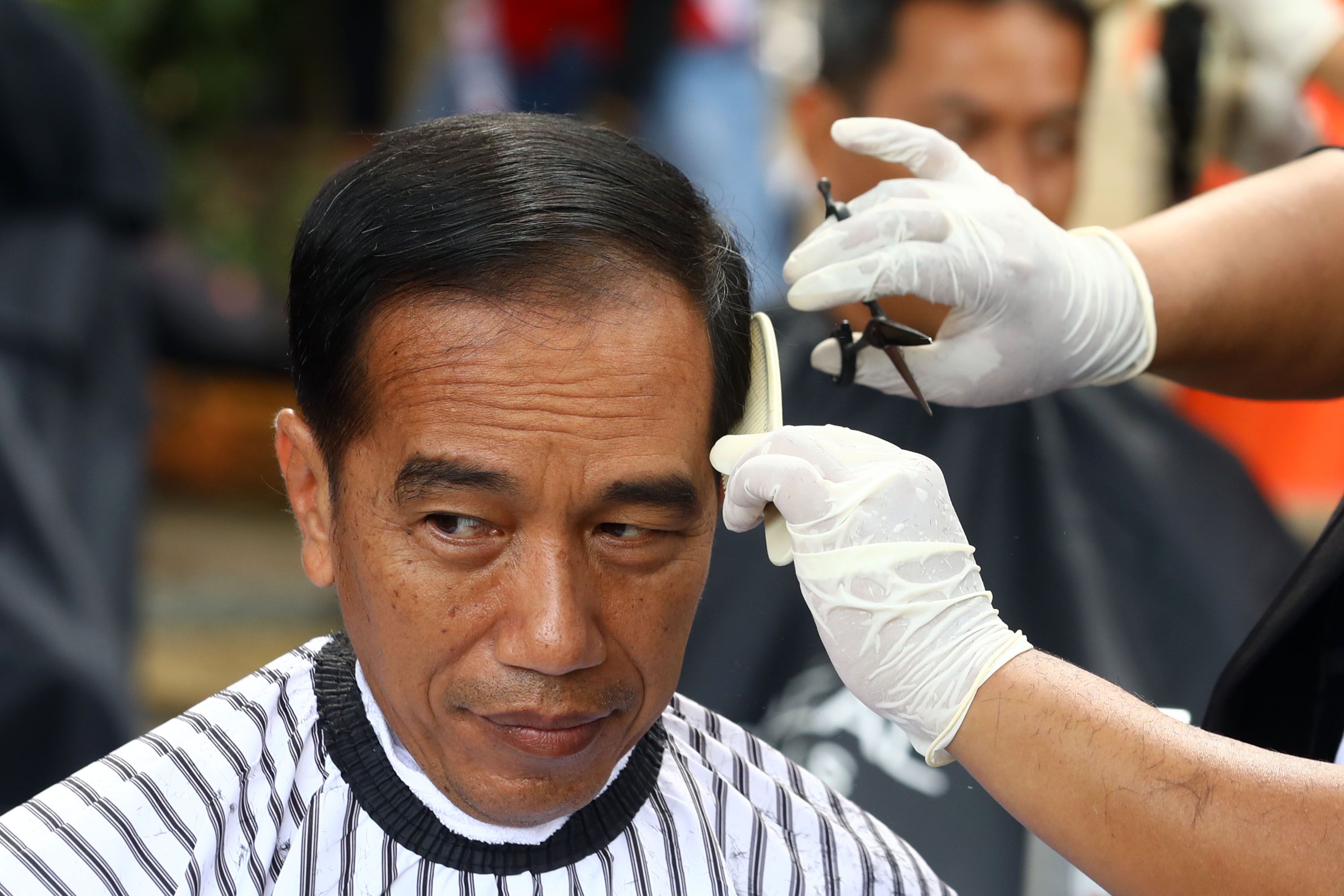 Presiden Joko Widodo mengikuti potong rambut massal di area wisata Situ Bagendit, Garut, Jawa Barat,