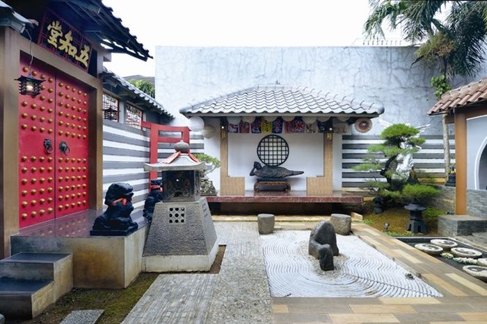Taman kering di bagian belakang rumah, bergaya Jepang dominan elemen keras.