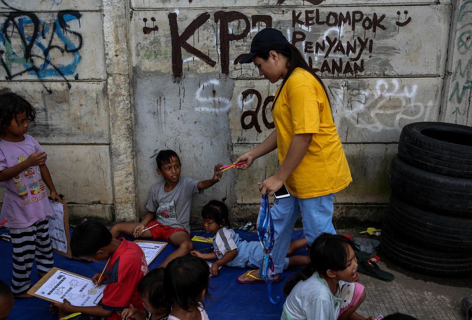 Sejumlah anak-anak saat belajar disebuah terpal yang disediakan oleh Relawan Mentari Senja di kawasan jalan inpeksi sungai banjir kanal barat, kawasan Tanah Abang, Jakarta, Kamis (7/2/2019). Relawan yang terdiri dari pemuda-pemudi yang masih sekolah dan kuliah ini melakukan kegiatan sosial dengan me