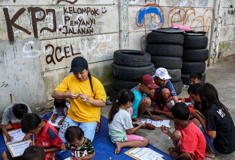 Sejumlah anak-anak saat belajar disebuah terpal yang disediakan oleh Relawan Mentari Senja di kawasan jalan inpeksi sungai banjir kanal barat, kawasan Tanah Abang, Jakarta, Kamis (7/2/2019). Relawan yang terdiri dari pemuda-pemudi yang masih sekolah dan kuliah ini melakukan kegiatan sosial dengan me