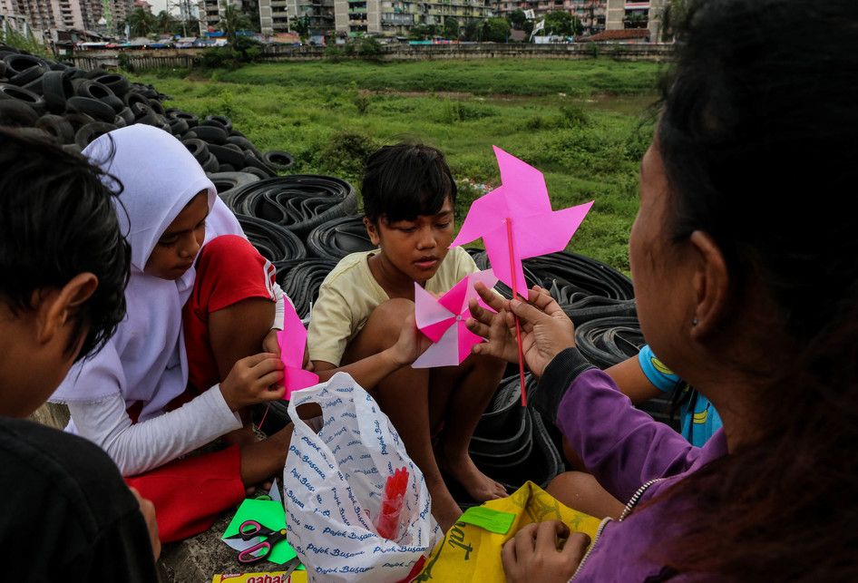 Sejumlah anak-anak saat belajar disebuah terpal yang disediakan oleh Relawan Mentari Senja di kawasan jalan inpeksi sungai banjir kanal barat, kawasan Tanah Abang, Jakarta, Kamis (7/2/2019). Relawan yang terdiri dari pemuda-pemudi yang masih sekolah dan kuliah ini melakukan kegiatan sosial dengan me