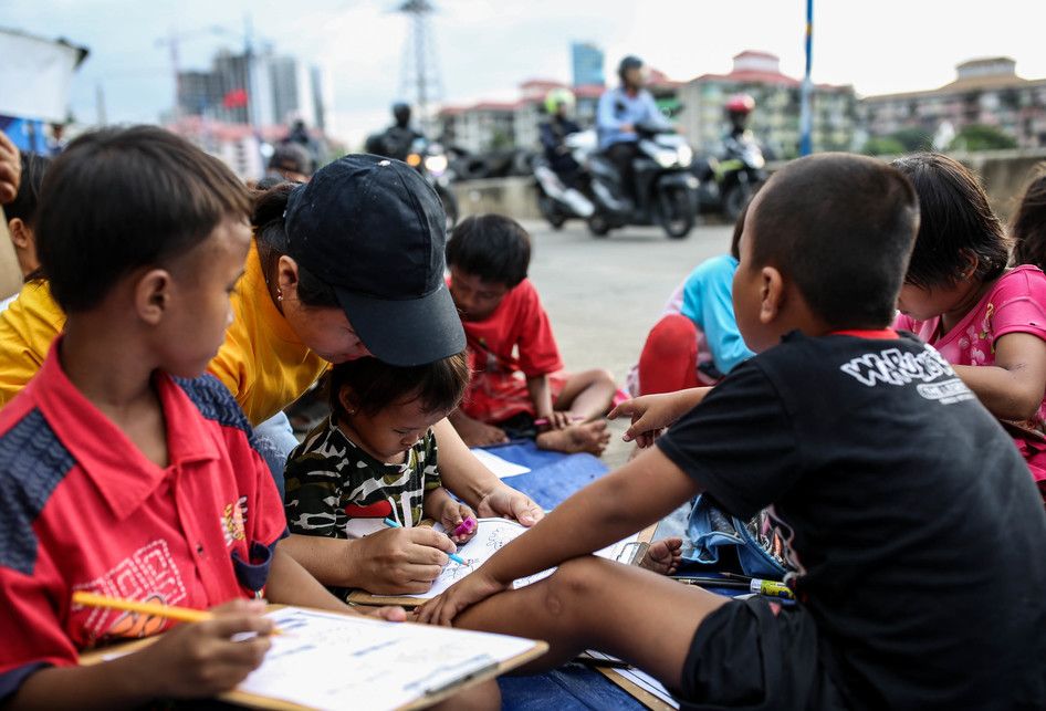 Sejumlah anak-anak saat belajar disebuah terpal yang disediakan oleh Relawan Mentari Senja di kawasan jalan inpeksi sungai banjir kanal barat, kawasan Tanah Abang, Jakarta, Kamis (7/2/2019). Relawan yang terdiri dari pemuda-pemudi yang masih sekolah dan kuliah ini melakukan kegiatan sosial dengan me