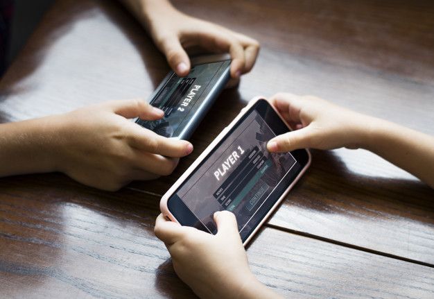 Little boy playing a mobile game against his sister