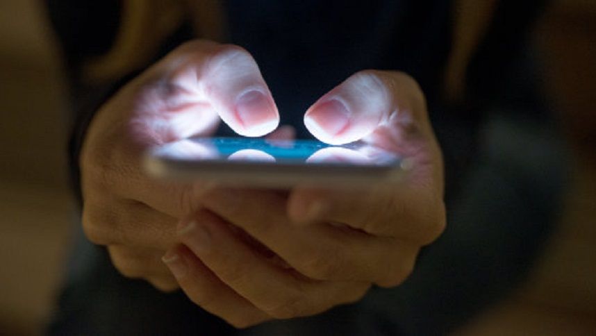 Female using her mobile phone outside at night