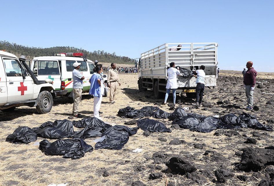 Petugas mengevakuasi jenazah di lokasi jatuhnya pesawat Ethiopia Airlines di kawasan Bishoftu, sebuah kota sekitar 60 kilometer tenggara Addis Ababa, Ethiopia, Minggu (10/3/2019). Sebanyak 157 orang terdiri dari penumpang dan kru pesawat Ethiopian Airlines dipastikan tewas setelah Boeing 737-8 MAX y