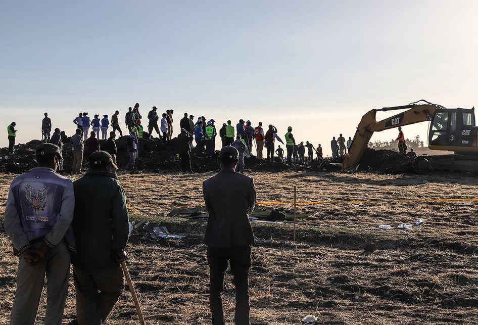 Sejumlah orang menyaksikan proses evakuasi di lokasi jatuhnya pesawat Ethiopia Airlines di kawasan Bishoftu, sebuah kota sekitar 60 kilometer tenggara Addis Ababa, Ethiopia, Minggu (10/3/2019). Sebanyak 157 orang terdiri dari penumpang dan kru pesawat Ethiopian Airlines dipastikan tewas setelah Boei