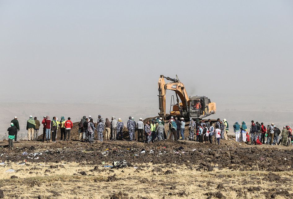 Sejumlah orang menyaksikan proses evakuasi di lokasi jatuhnya pesawat Ethiopia Airlines di kawasan Bishoftu, sebuah kota sekitar 60 kilometer tenggara Addis Ababa, Ethiopia, Senin (11/3/2019). Sebanyak 157 orang terdiri dari penumpang dan kru pesawat Ethiopian Airlines dipastikan tewas setelah Boein