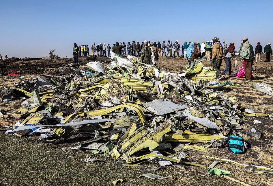 Sejumlah orang menyaksikan proses evakuasi di lokasi jatuhnya pesawat Ethiopia Airlines di kawasan Bishoftu, sebuah kota sekitar 60 kilometer tenggara Addis Ababa, Ethiopia, Senin (11/3/2019). Sebanyak 157 orang terdiri dari penumpang dan kru pesawat Ethiopian Airlines dipastikan tewas setelah Boein