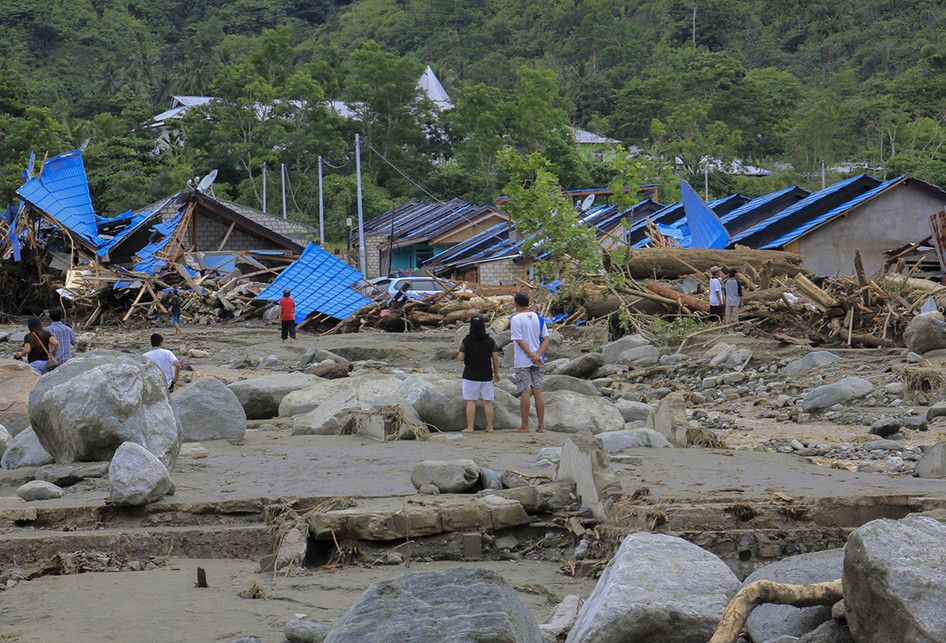 Sejumlah warga melihat rumah yang rusak akibat banjir bandang di Sentani, Kabupaten Jayapura, Papua, Minggu (17/3/2019). Jumlah korban bencana banjir bandang yang terjadi pada Sabtu (16/3/2019) malam kemarin, hingga data yang masuk pada Minggu sore, terus bertambah menjadi 63 orang.