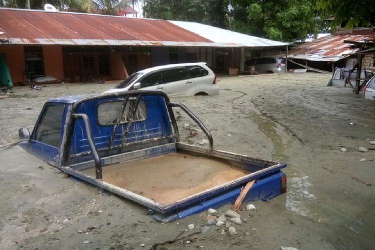Sejumlah kendaraan terendam lumpur saat banjir bandang di Sentani, Kabupaten Jayapura, Papua, Minggu (17/3/2019). Berdasarkan data BNPB, banjir bandang yang terjadi pada Sabtu (16/3) tersebut mengakibatkan 42 orang tewas. 