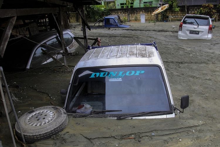 Sejumlah kendaraan terendam lumpur saat banjir bandang di Sentani, Kabupaten Jayapura, Papua, Minggu (17/3/2019).  