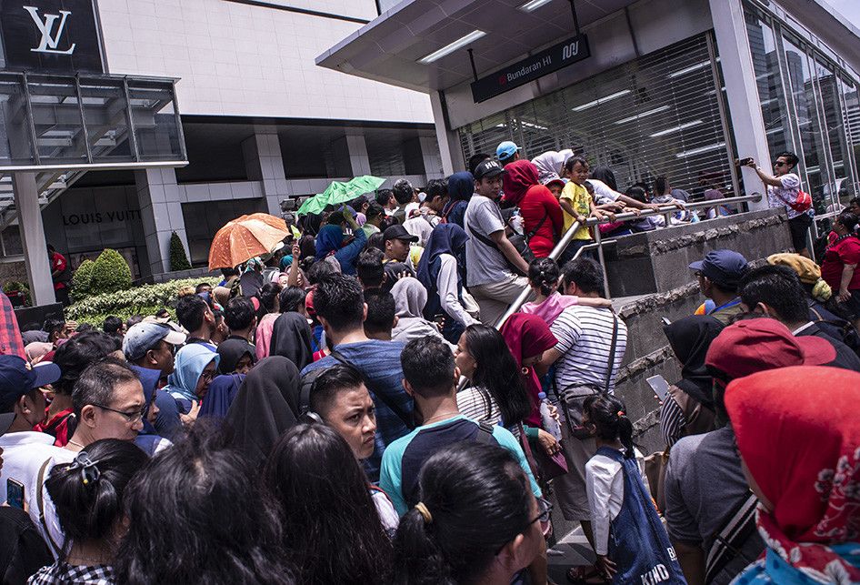 Warga mengantri untuk menaiki kereta MRT di pintu masuk Stasiun MRT Bundaran HI, Jakarta, Minggu (24/3/2019). Moda Raya Terpadu (MRT) Jakarta Fase 1 dengan rute Bundaran HI - Lebak Bulus resmi beroperasi sejak diresmikan oleh Presiden Jokowi, Minggu hari ini.