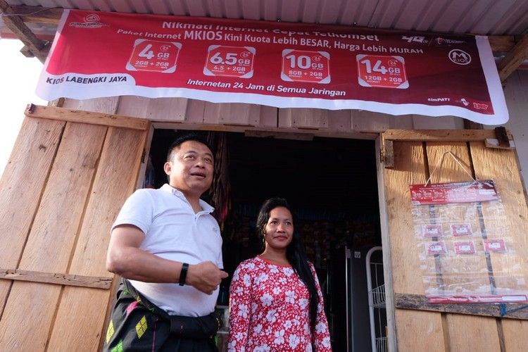 Direktur Utama Telkomsel Ririek Adriansyah (kiri) bersama salah satu warga di Desa Labengki yang sudah membuka usaha isi ulang pulsa ataupun paket internet.