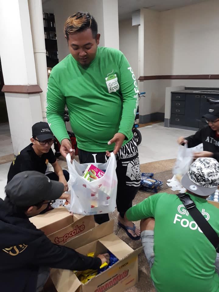 Terlihat abang grab yang sedang membagikan makanan