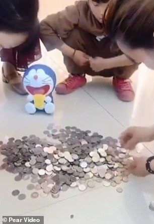 Staf toko menghitung koin yang dibawa Guo