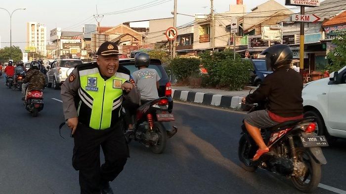 Kompol Tutu Mulyana mengatur arus lalu lintas sambil Goyang Boboho
