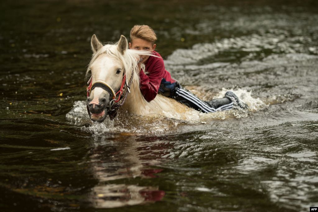Seorang pemuda memandikan kudanya di Sungai Eden pada hari kedua Festival Tahunan Kuda Appleby di kota Appleby-in-Westmorland, baratdaya Inggris.