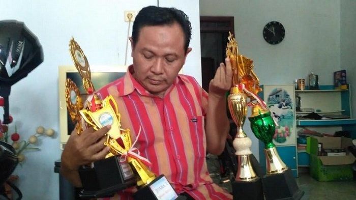 Sugeng Witoto, ayah Y saat memperlihatkan piala yang didapat anaknya