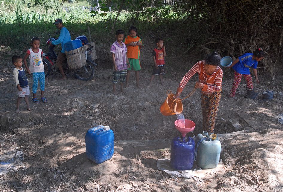 Warga Desa Keyongan, Kecamatan Gabus, Kabupaten Grobogan, Jawa Tengah mengambil air keruh untuk kebutuhan sehari-hari dari dasar sungai setempat yang sudah mengering, Rabu (26/6/2019) pagi. Tanah tandus yang digali seukuran tong sampah itu biasa disebut dengan nama 'belik'.