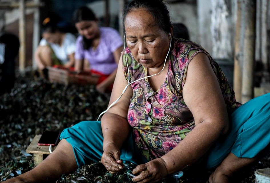 Warga kampung kerang hijau sedang mengupas kerang hasil budidaya nelayan yang ada di Muara Angke, Penjaringan, Jakarta Utara, Jumat (5/7/2019). Kawasan ini merupakan sentra pengolahan kerang hijau yang ada di bibir pantai utara Jakarta.