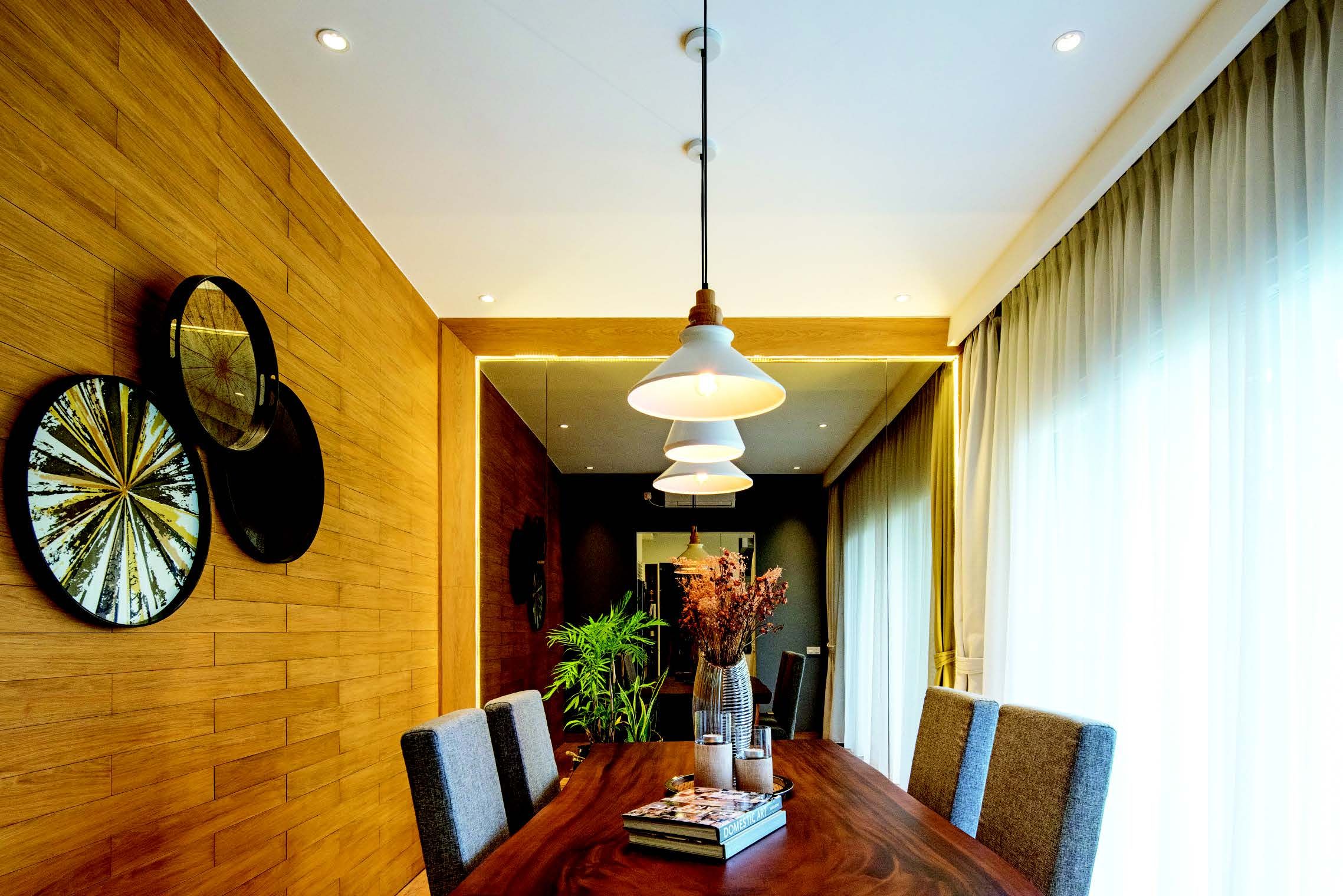 Indahnya ruang makan yang mengaplikasikan dinding panel dari kayu. Ruang ini juga memiliki jendela yang memungkinkan masuknya sinar alami sepanjang hari.