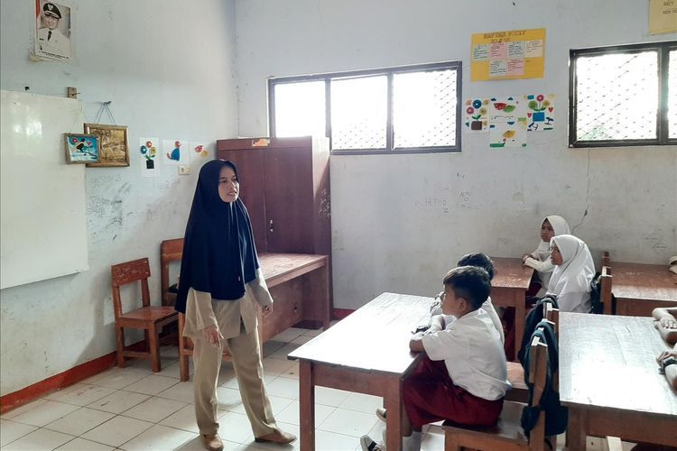 Nining Suryani mengajar dalam salah satu ruang kelas di SDN Karyabuana 3, Pandeglang, Banten pada Senin (15/7).