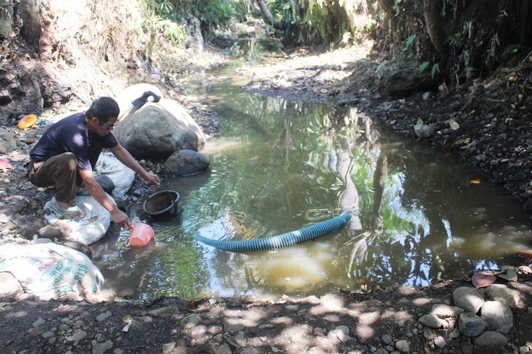 Seorang warga di Desa Cisalak, Kec. Cibeber, Kab. Cianjur, Jawa Barat tengah memanfaatkan air kubangan Kali Cisalak, Minggu (21/072019) menyusul krisis air di wilayah tersebut sejak dua bulan terakhir.