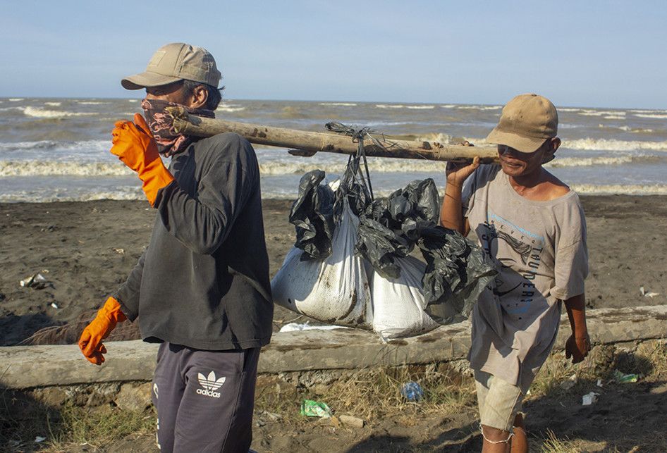 Warga membawa karung berisi pasir yang tercemar tumpahan minyak mentah (Oil Spill) di pesisir Pantai Cemarajaya, Karawang, Jawa Barat, Rabu (24/7/2019). Karung berisi pasir yang tercemar minyak mentah tersebut dikumpulkan dan akan dipindahkan ke lokasi penyimpanan limbah B3 (Bahan Berbahaya dan Bera